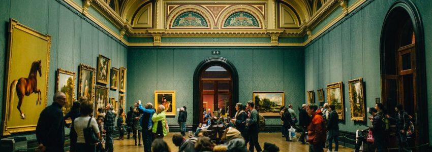 Salle d'un musée avec ses visiteurs découvrant des peintures